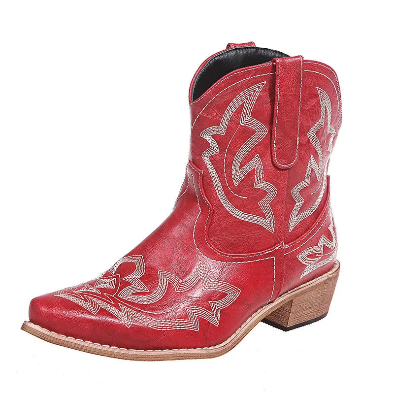 Blue women's cowboy ankle boots with embroidery and a low wedge heel on a wooden floor.