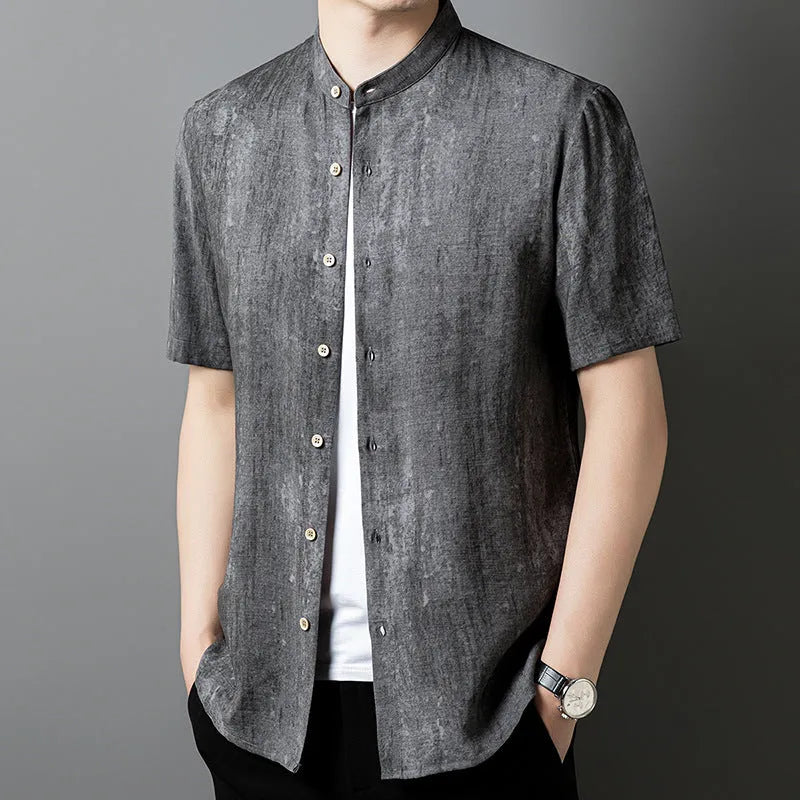 Man wearing a loose-fit grey linen blend short-sleeve shirt with a stand collar.