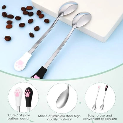 Two pet food spoons with cat paw designs - one white and one black with stainless steel and silicone construction