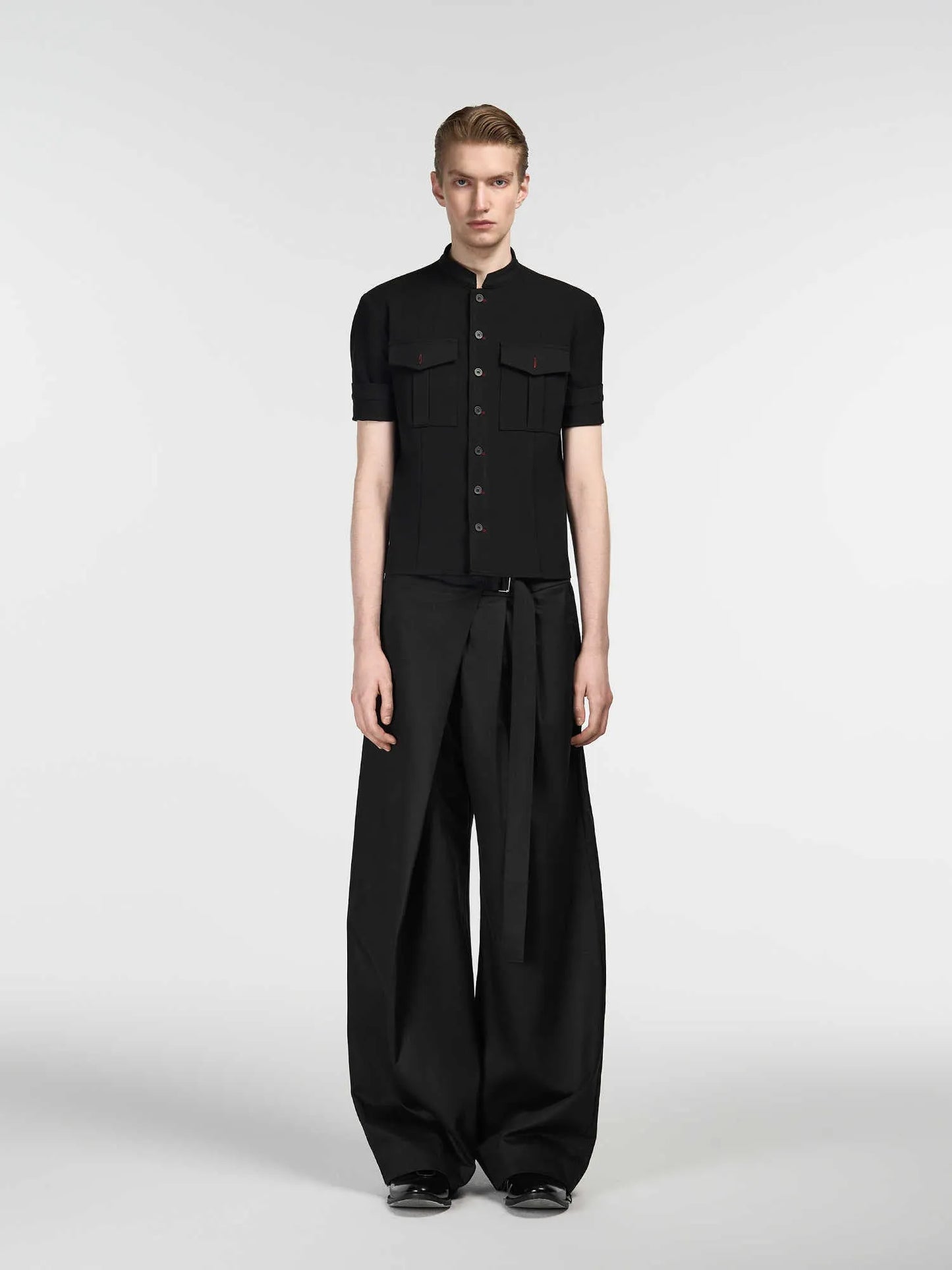 Black straight-leg trousers with a single pleat and adjustable waistband on a hanger.