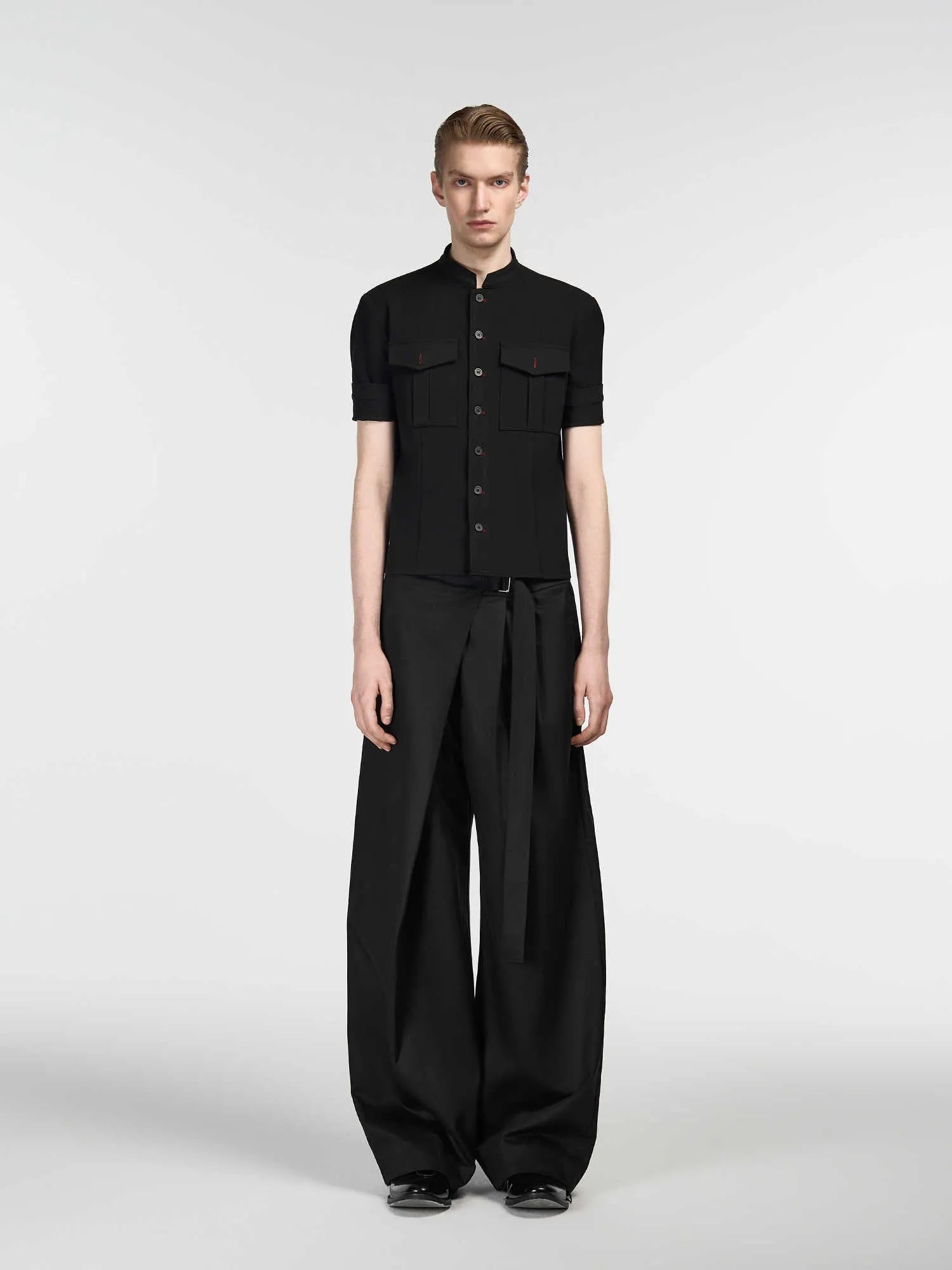 Black straight-leg trousers with single front pleat and adjustable waistband on a hanger