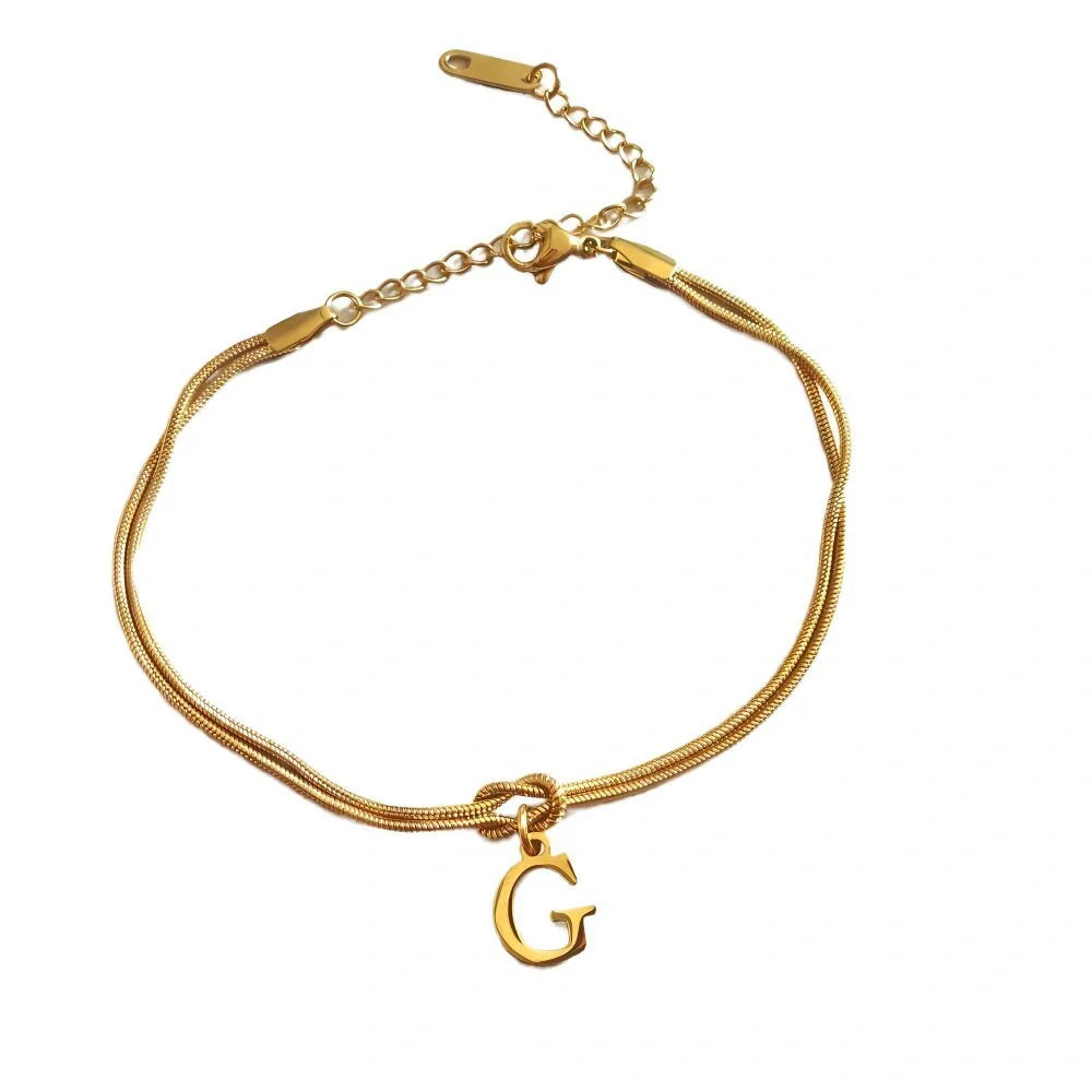 Elegant letter charm bracelets for women in gold and silver tones, featuring a delicate snake chain design and personalised letter charms.