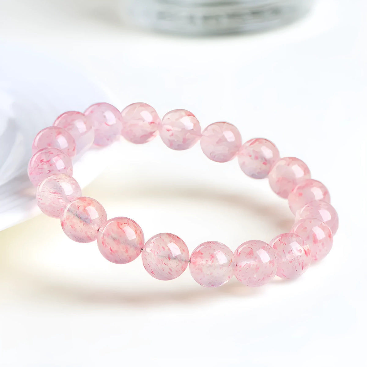 Unisex white strawberry quartz bracelet with round 10mm geometric beads on a string.