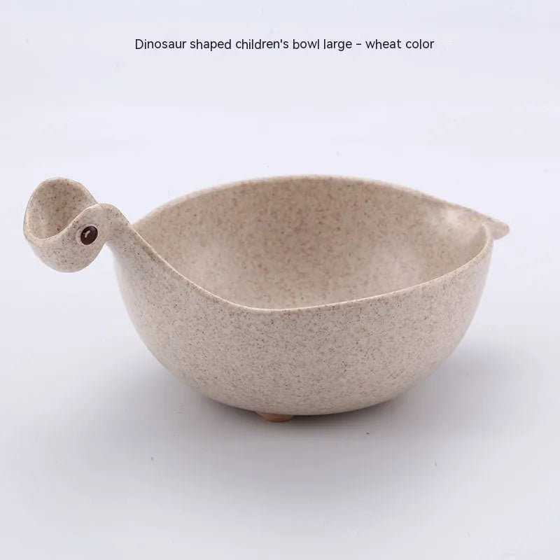 Three colourful dinosaur-shaped bowls made from wheat straw in pink, green, and beige.
