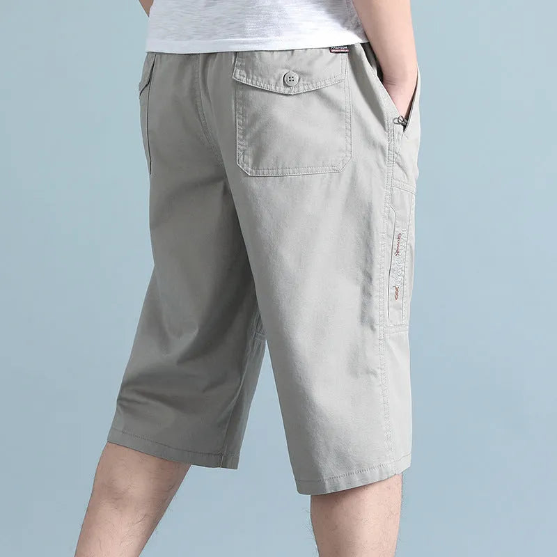 Man wearing loose grey cotton sports pants with a straight leg and cropped length.