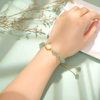 Adjustable rabbit charm bracelet with natural stone beads and gold plated details on a wrist.
