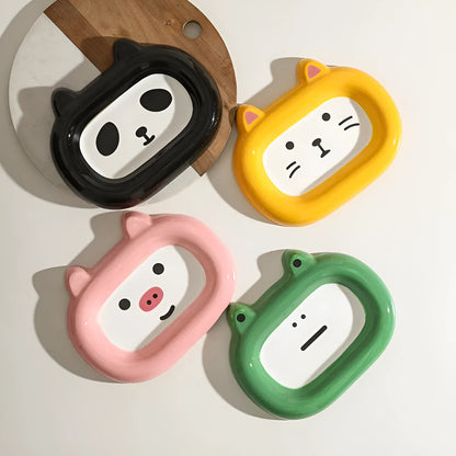 Four ceramic animal-themed pet bowls with frog, panda, pig, and fortune cat designs and silicone non-slip bases