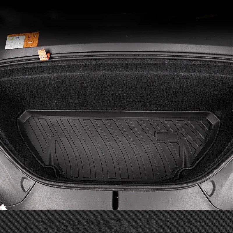 Custom black rubber floor mats with textured surface and TPE driver's footrest, fitted in a Tesla interior.