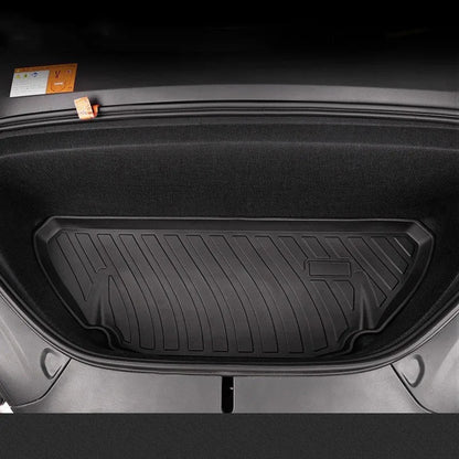 Custom black rubber floor mats with textured surface and TPE driver's footrest, fitted in a Tesla interior.