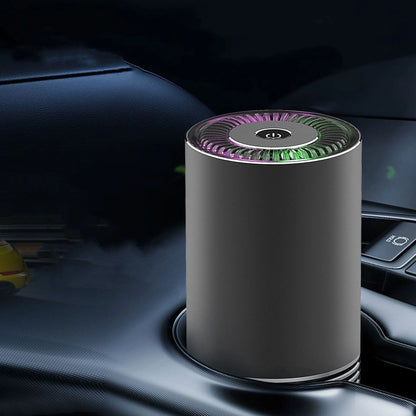 Compact black car air purifier with aluminium alloy and ABS construction, shown next to a car USB port.