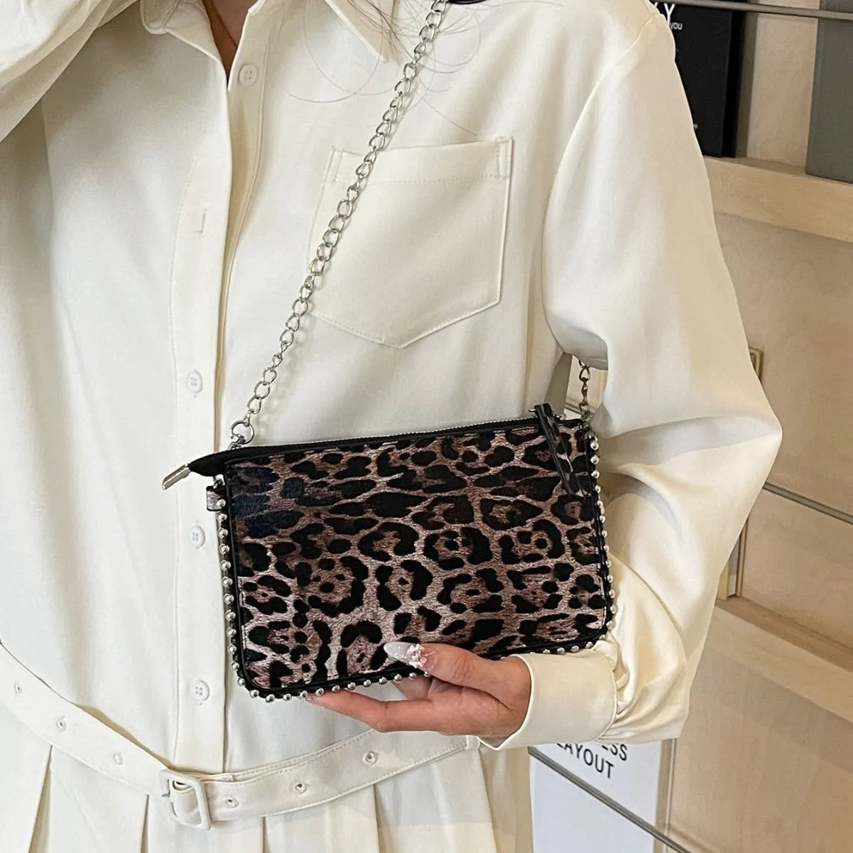 Western style women's brown crossbody bag with chain strap and horizontal square silhouette