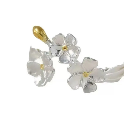Three-dimensional floral jasmine ring with open-mouth adjustable design on a plain background.