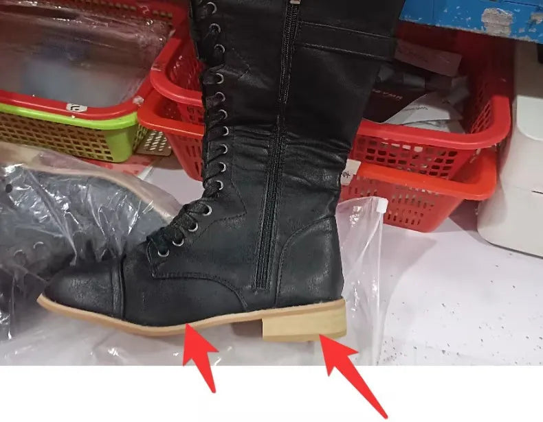 Women's black knight ankle boots with cross straps and buckles over lace-up front.