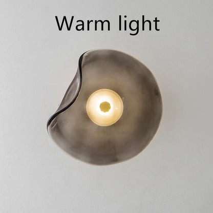 Round glass wall lamp mounted beside bed in cognac colour with 220V operation for bedside lighting
