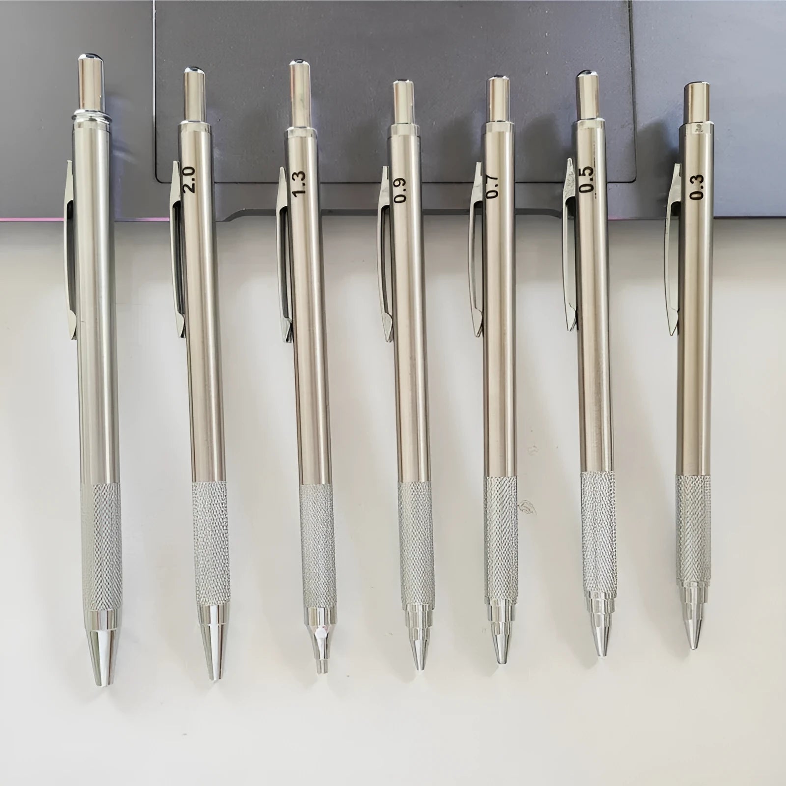 Metal automatic mechanical pencil showing multiple lead diameter options including 0.5 mm, 0.7 mm, 0.9 mm, 1.3 mm, and 2.0 mm