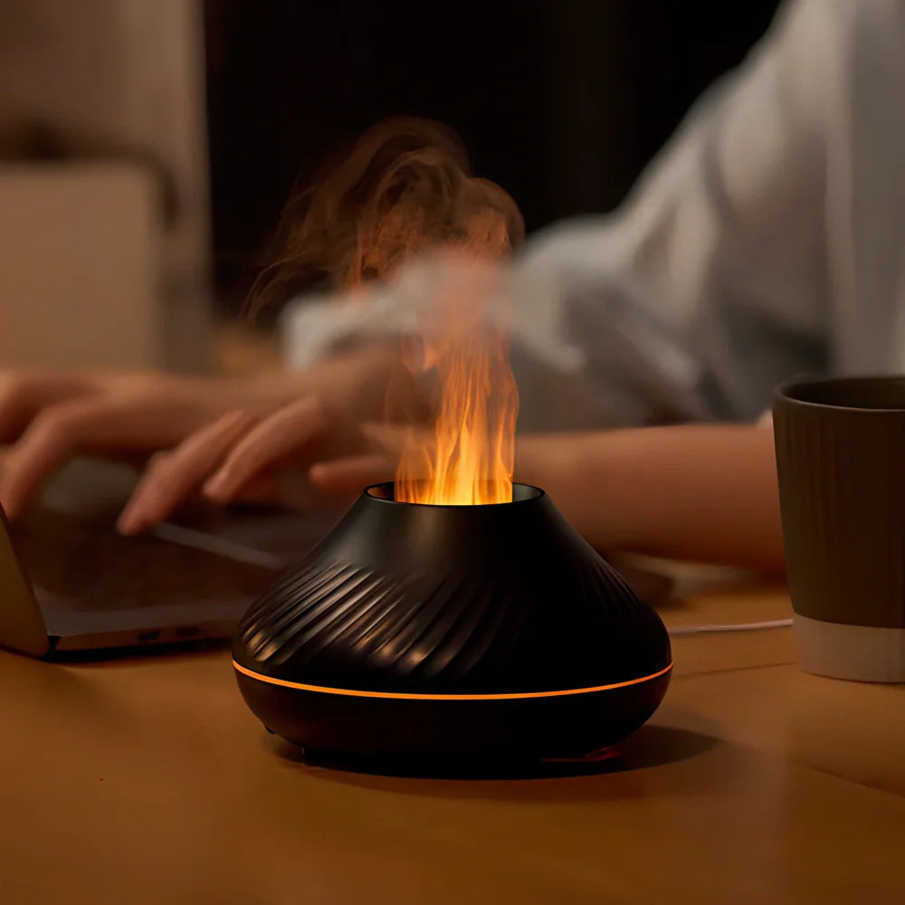 Black RGB flame aroma diffuser 130ml showing 3D colourful volcano mist effect on table