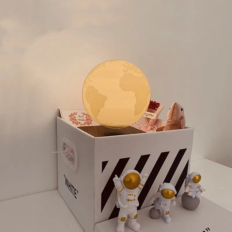 Maglev floating moon planet atmosphere night light with three astronaut figurines on a desk.