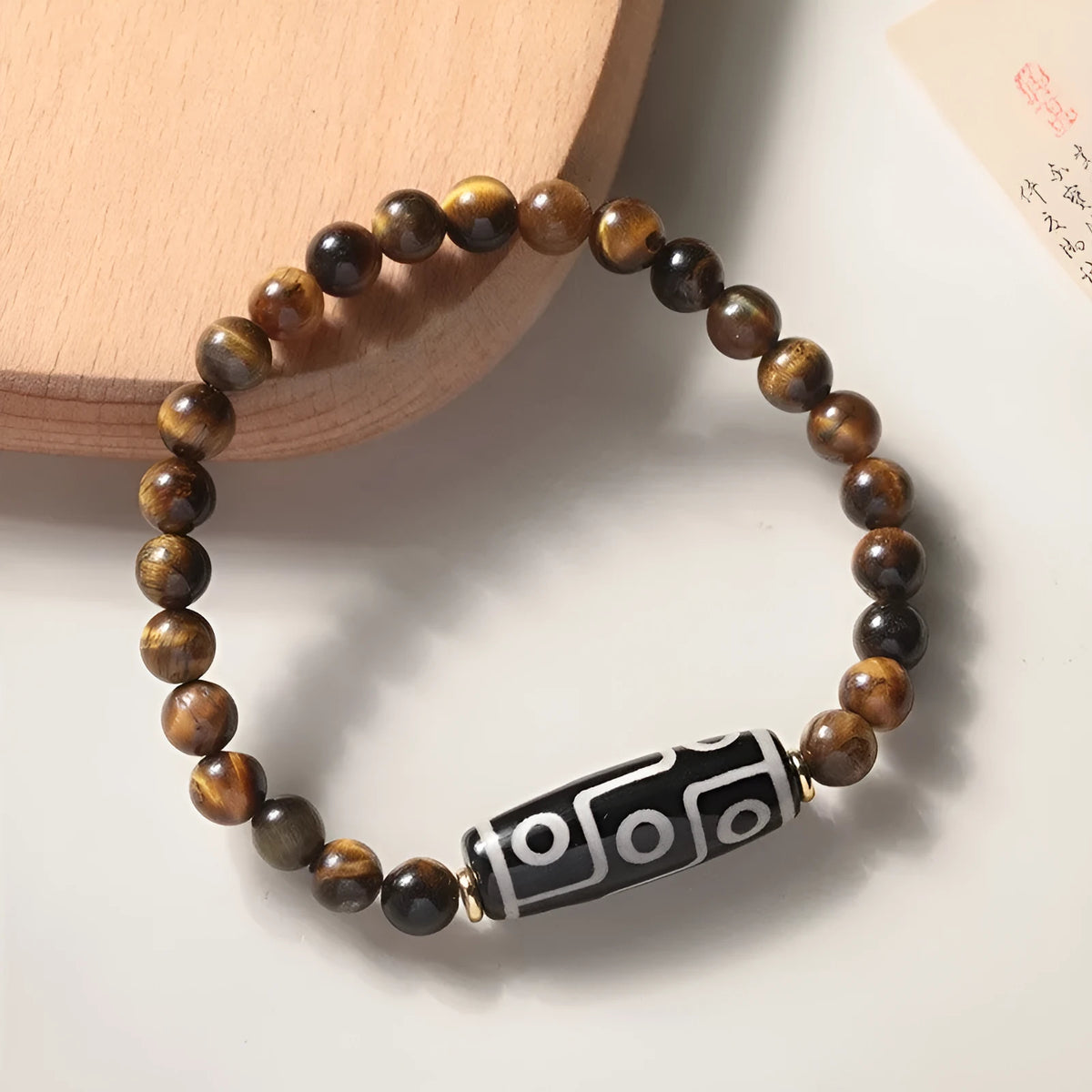 Tigereye dzi bead buddha bracelet with adjustable closure, shown in simple bracelet style.