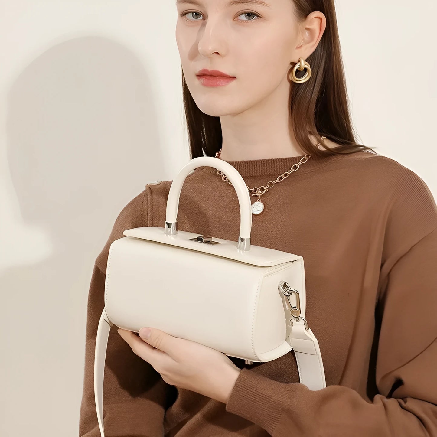 Women's leather one-shoulder crossbody bag in cowhide with clamshell design and internal phone pocket