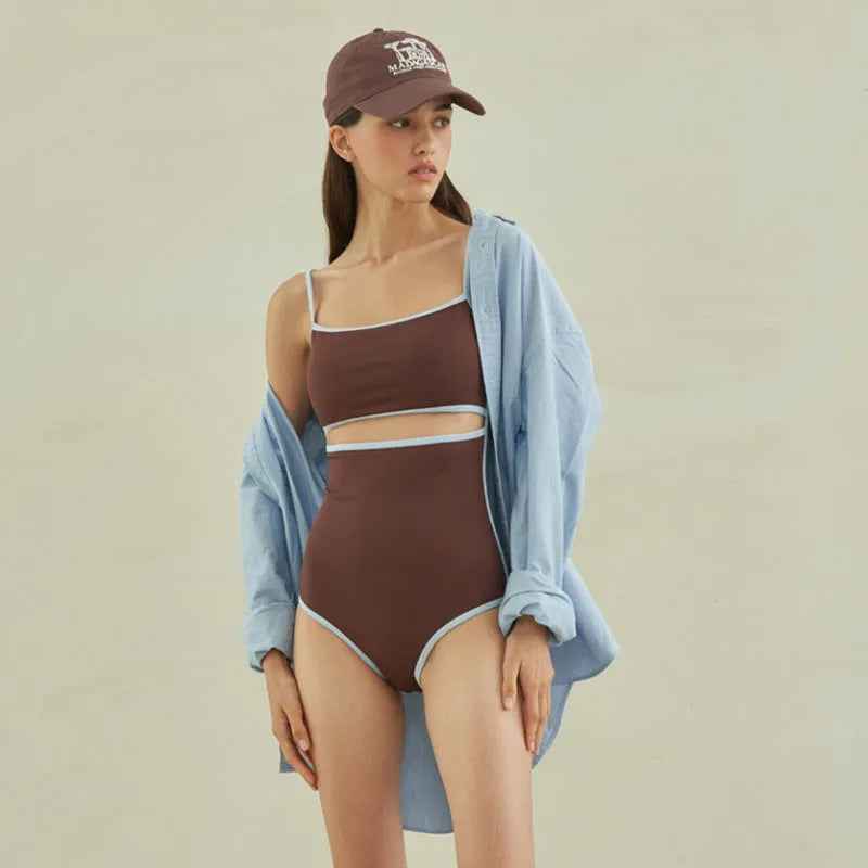 Brown women's one-piece swimsuit with triangle front and adjustable tie-back straps on a neutral background.