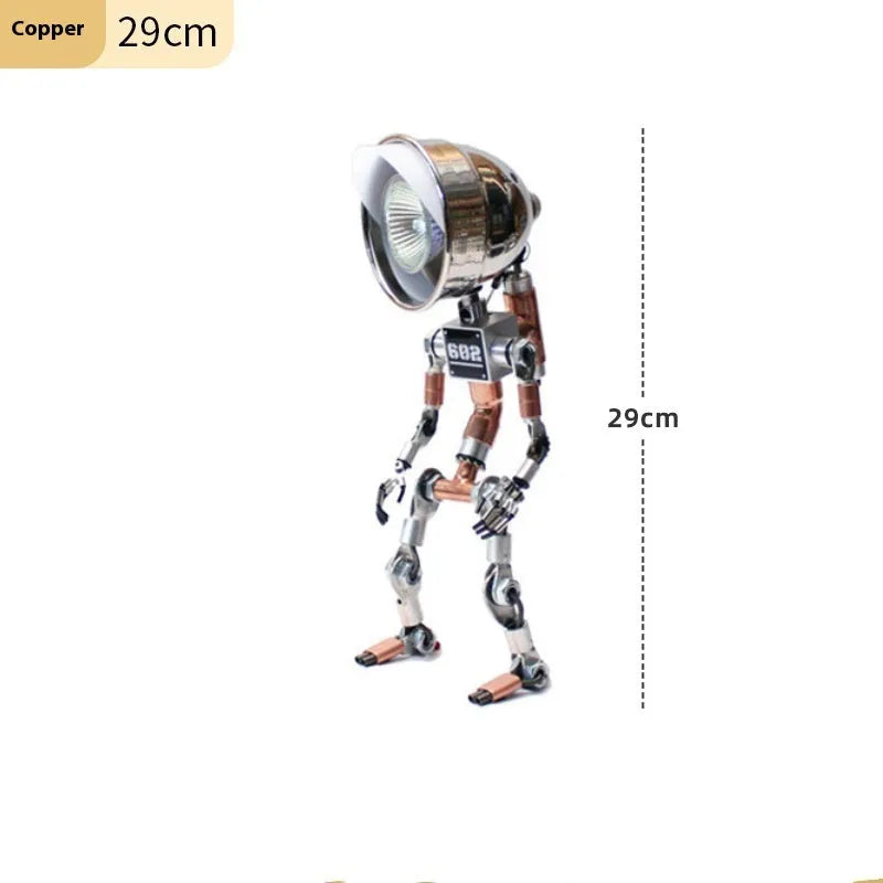 Silver copper robot-shaped decorative desk lamp with custom graphic option on a wooden shelf.