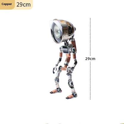 Silver copper robot-shaped decorative desk lamp with custom graphic option on a wooden shelf.