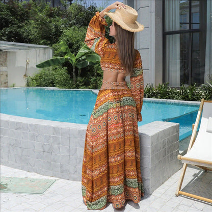 Elegant floral print dress with long sleeves and empire waistline in vibrant orange color