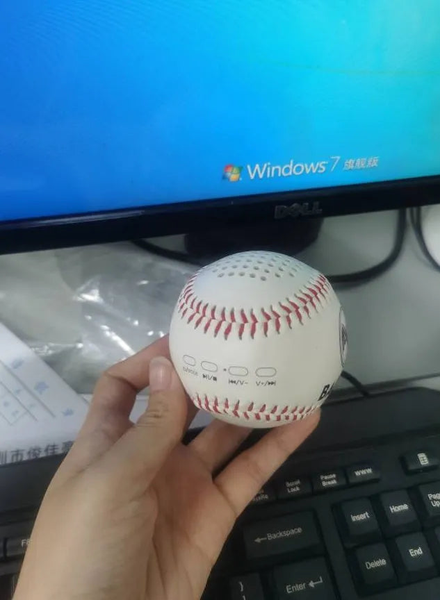 A green Bluetooth speaker shaped like a baseball with a USB port.