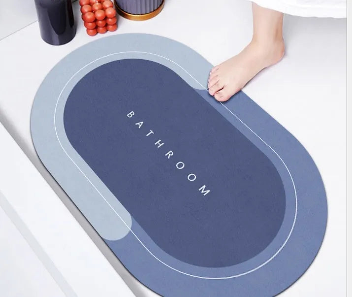 Oval diatomite bathroom floor mat in blue with natural rubber non-slip backing on tiled floor.