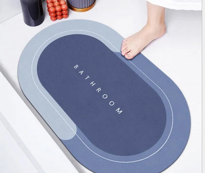 Oval diatomite bathroom floor mat in blue with natural rubber non-slip backing on tiled floor.