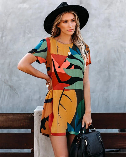 Stylish short-sleeved dress with a vibrant graffiti print and round neckline
