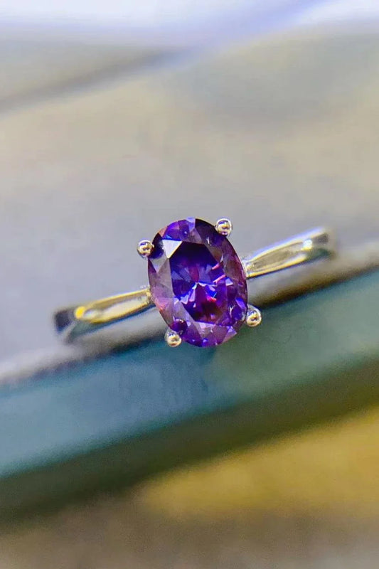 A sparkling 1 carat moissanite stone set in a 925 sterling silver 4-prong solitaire ring with a platinum-plated finish.