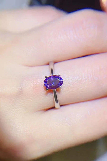 A sparkling 1 carat moissanite stone set in a 925 sterling silver 4-prong solitaire ring with a platinum-plated finish.