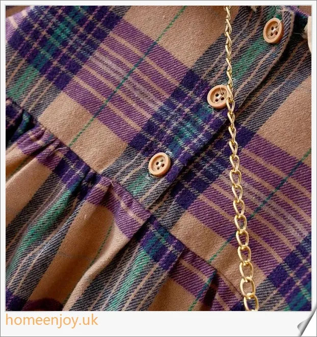 Baby girl wearing a long-sleeve dress with a grid pattern in purple and khaki colours