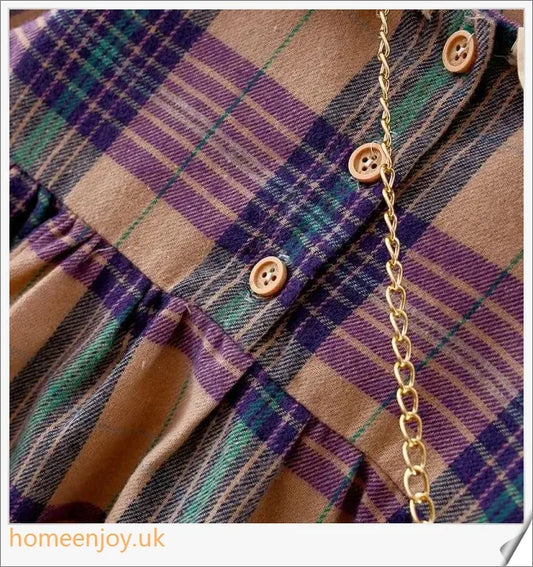 Baby girl wearing a long-sleeve dress with a grid pattern in purple and khaki colours