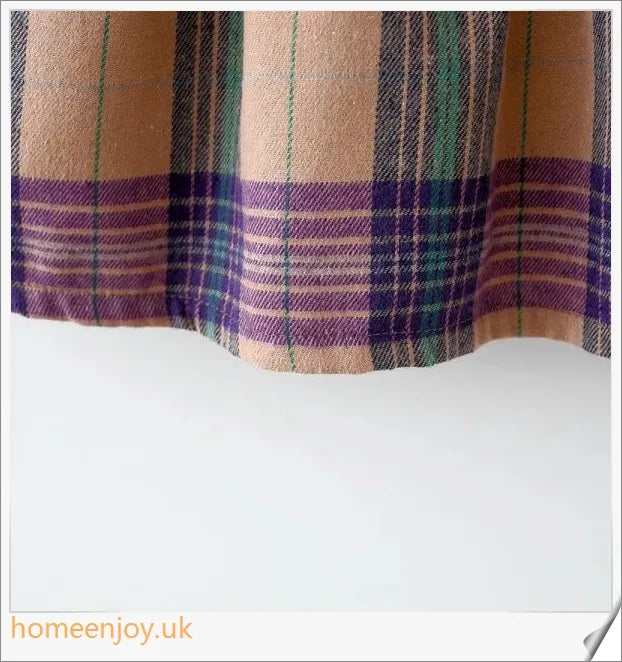 Baby girl wearing a long-sleeve dress with a grid pattern in purple and khaki colours