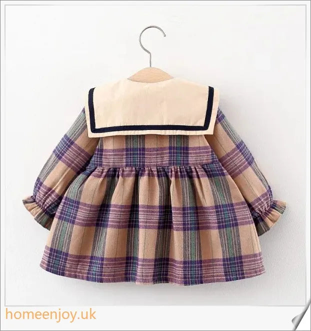 Baby girl wearing a long-sleeve dress with a grid pattern in purple and khaki colours