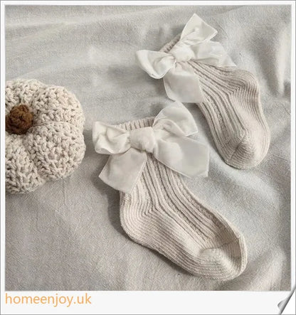 Soft, cosy baby socks with a charming bowknot design, available in a variety of classic colours