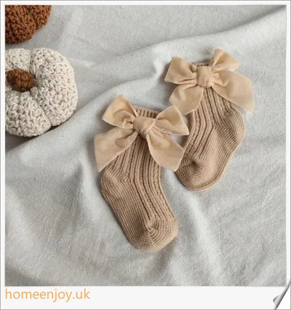 Soft, cosy baby socks with a charming bowknot design, available in a variety of classic colours
