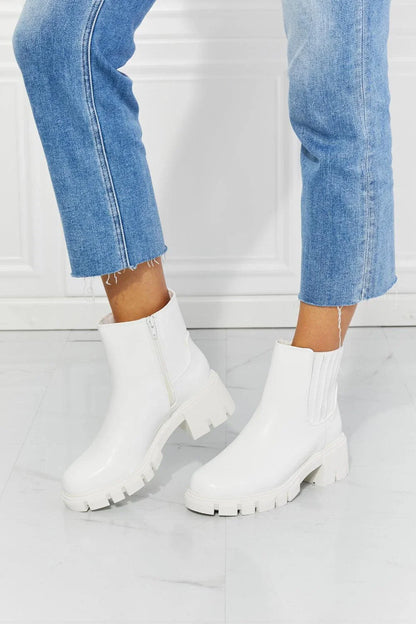 Faux patent leather lug sole Chelsea boots with a 2.5-inch block heel and a stretchy panel for easy on and off.