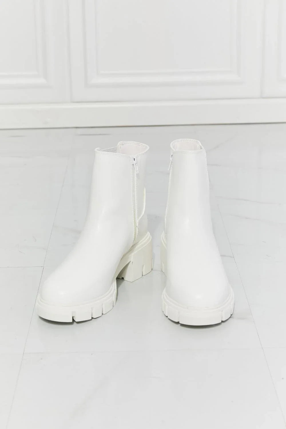 Faux patent leather lug sole Chelsea boots with a 2.5-inch block heel and a stretchy panel for easy on and off.