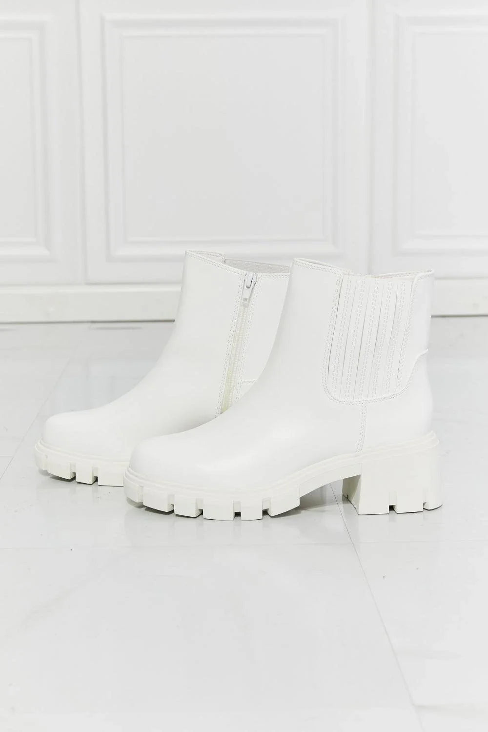 Faux patent leather lug sole Chelsea boots with a 2.5-inch block heel and a stretchy panel for easy on and off.