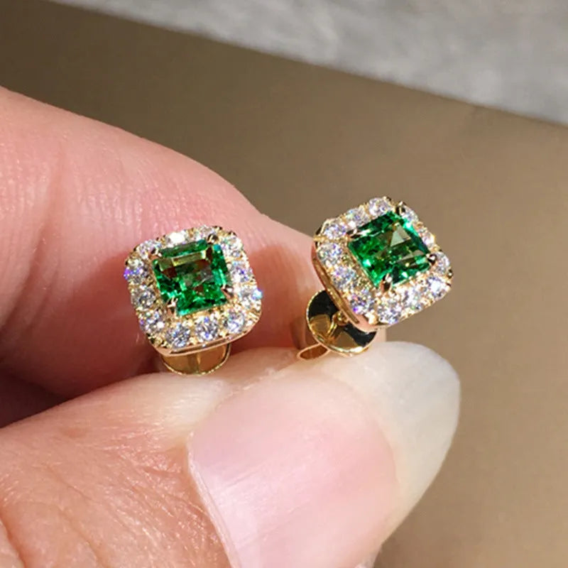 A pair of square cut grandmother green zircon stud earrings with a gold electroplated finish on a white background.