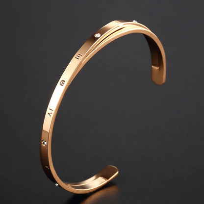 Open-ended women's bracelet with inlaid zircon stones on a stainless steel band in a gold colour finish.