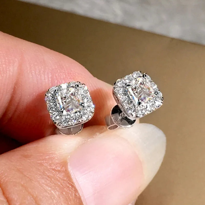 A pair of square cut grandmother green zircon stud earrings with a gold electroplated finish on a white background.