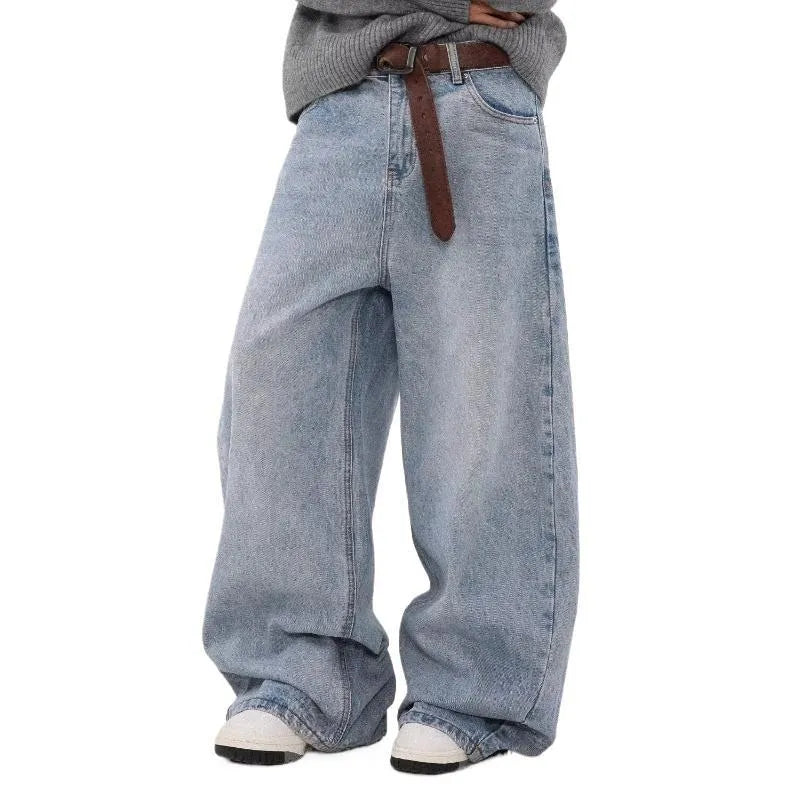 Man wearing retro blue washed straight leg distressed jeans with a mid-rise waist.