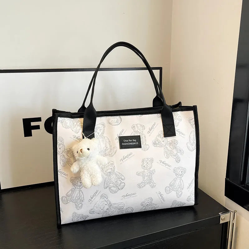 Women's black and white soft canvas tote bag with large capacity and printed rhombus pattern on front.