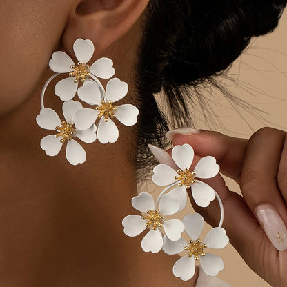 A pair of retro-style flower-shaped earrings for women, shown in black and white colour options.
