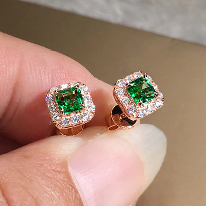 A pair of square cut grandmother green zircon stud earrings with a gold electroplated finish on a white background.