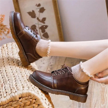 Black retro women's Mary Jane shoes with lace-up front and low square heel on a white background.